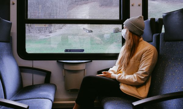 woman in the train sitting wearing a face mask